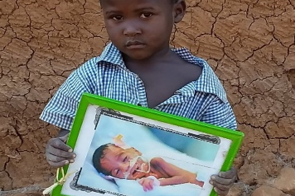 Sally holding a picture of her as a baby in the NICU