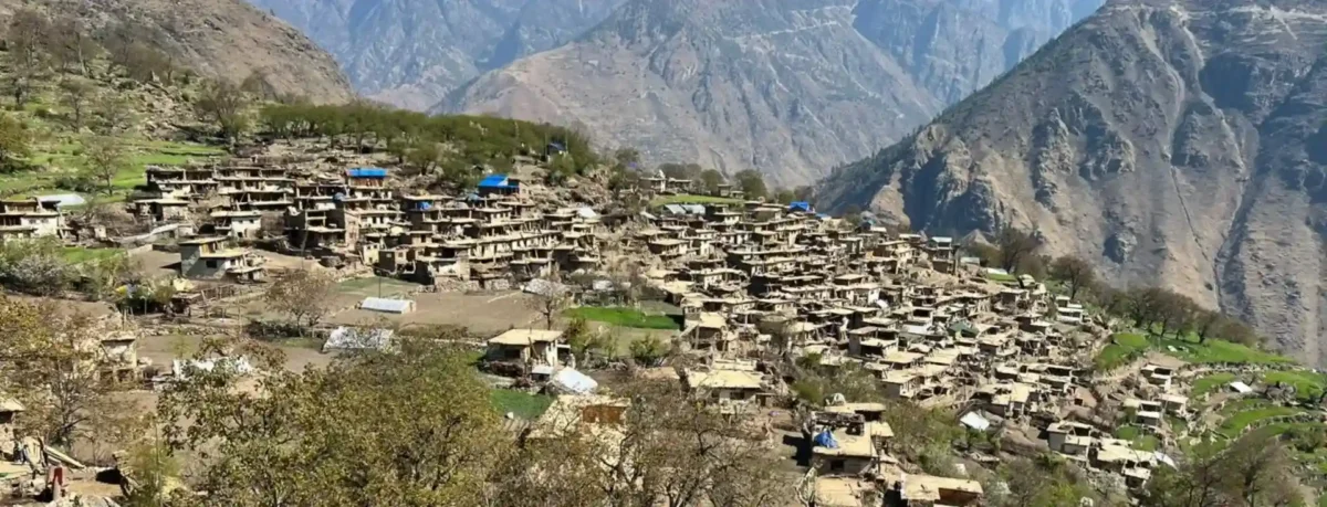 Mountain village with stone houses and terraced fields.